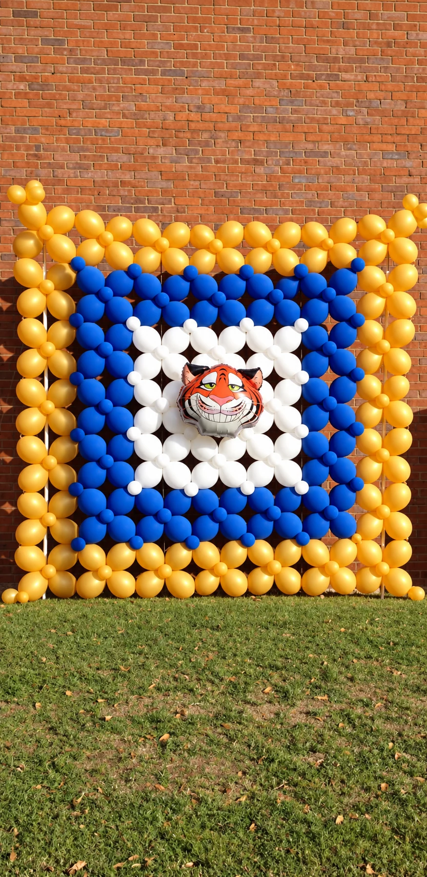 Blue and gold school-themed balloon wall with tiger mascot