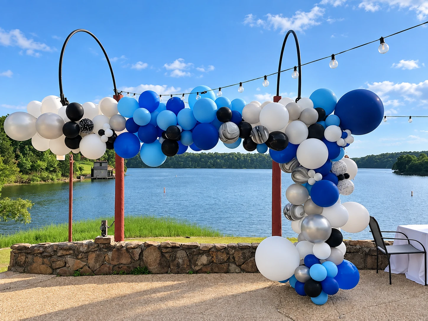 Blue and white organic balloon garland overlooking a lake