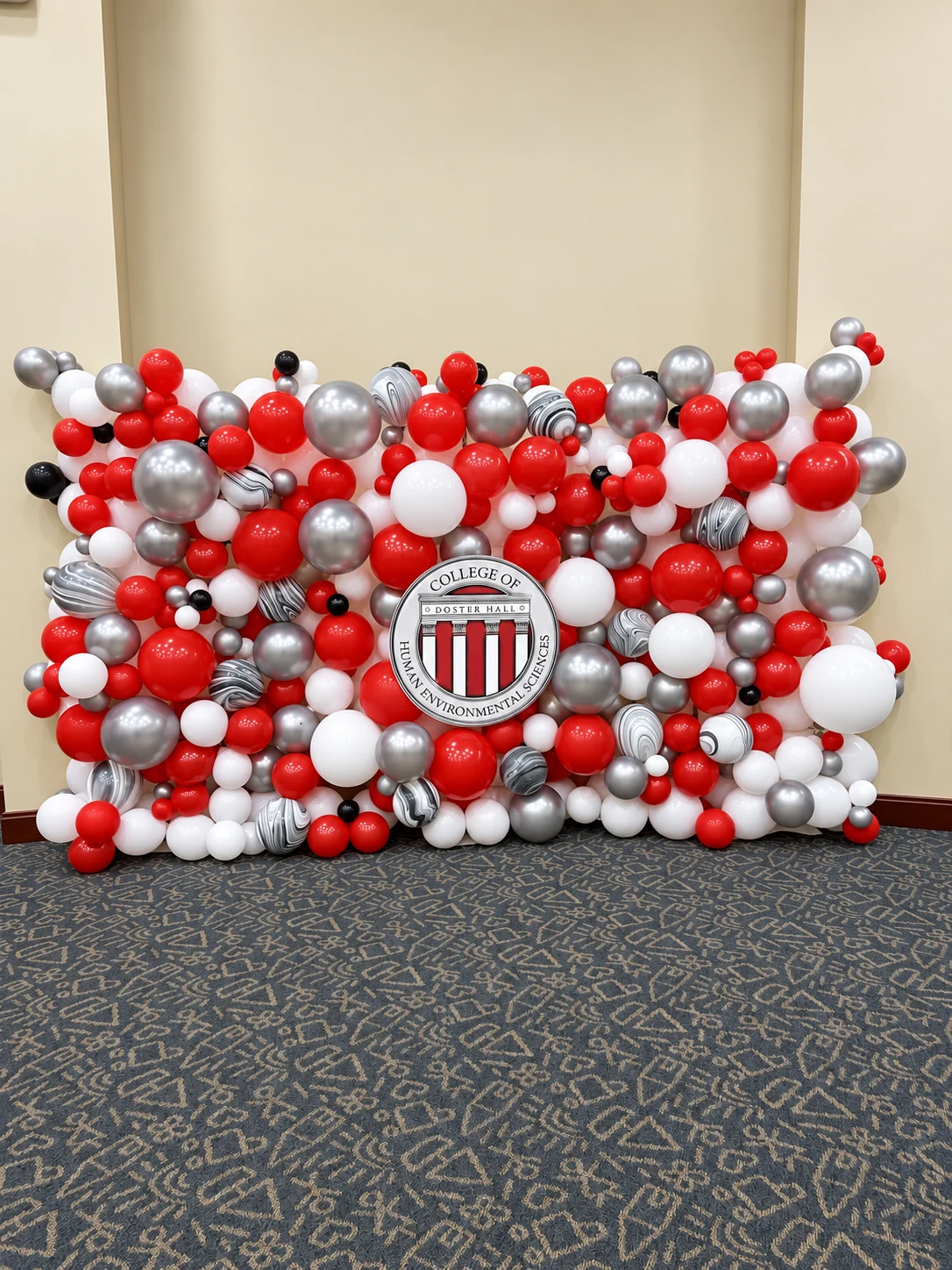 Crimson, silver and white organic balloon wall with university emblem