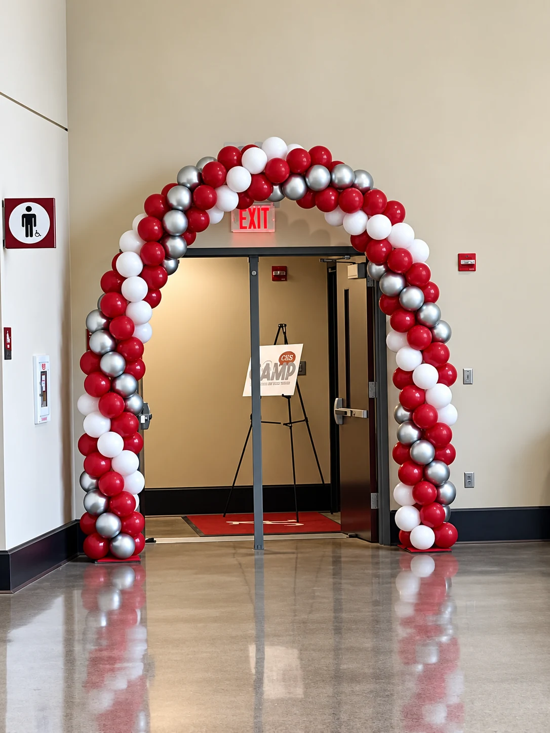 Classic crimson and white balloon arch at a university event