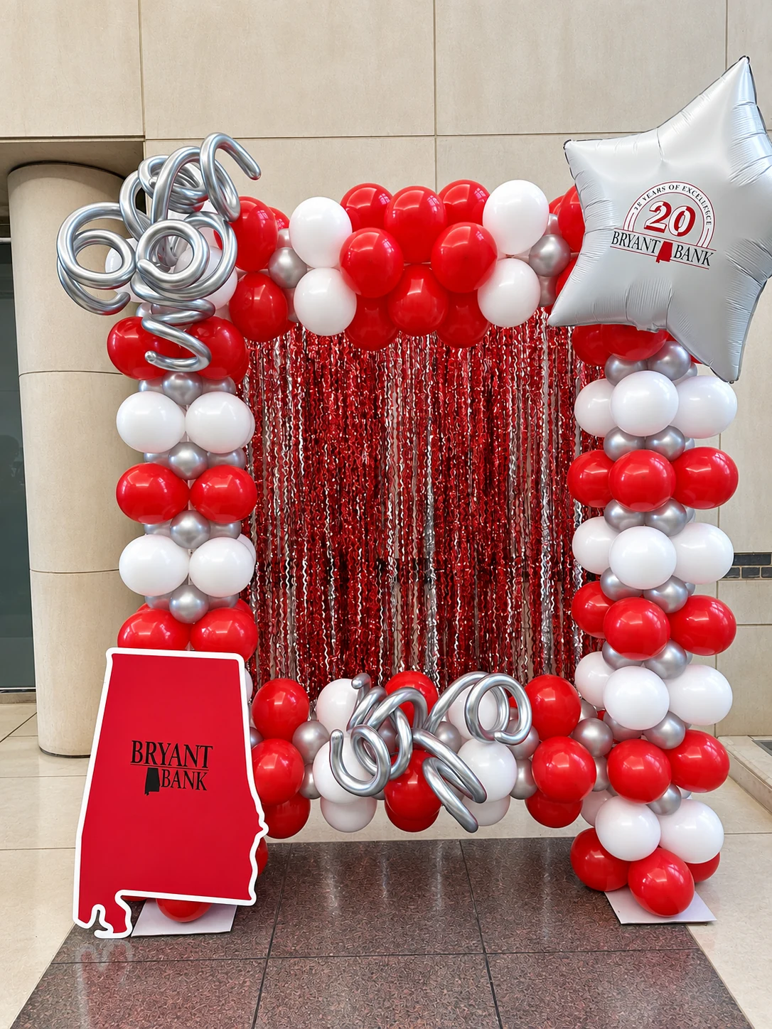 Crimson, white and silver milestone balloon backdrop with shimmer curtain