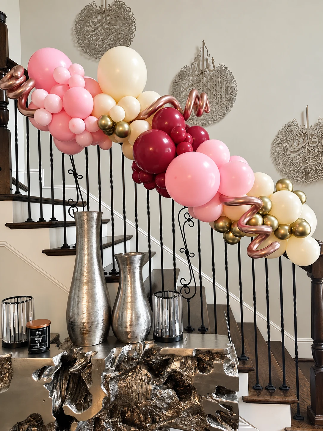 Pink, cream and rose-gold balloon garland decorating a staircase