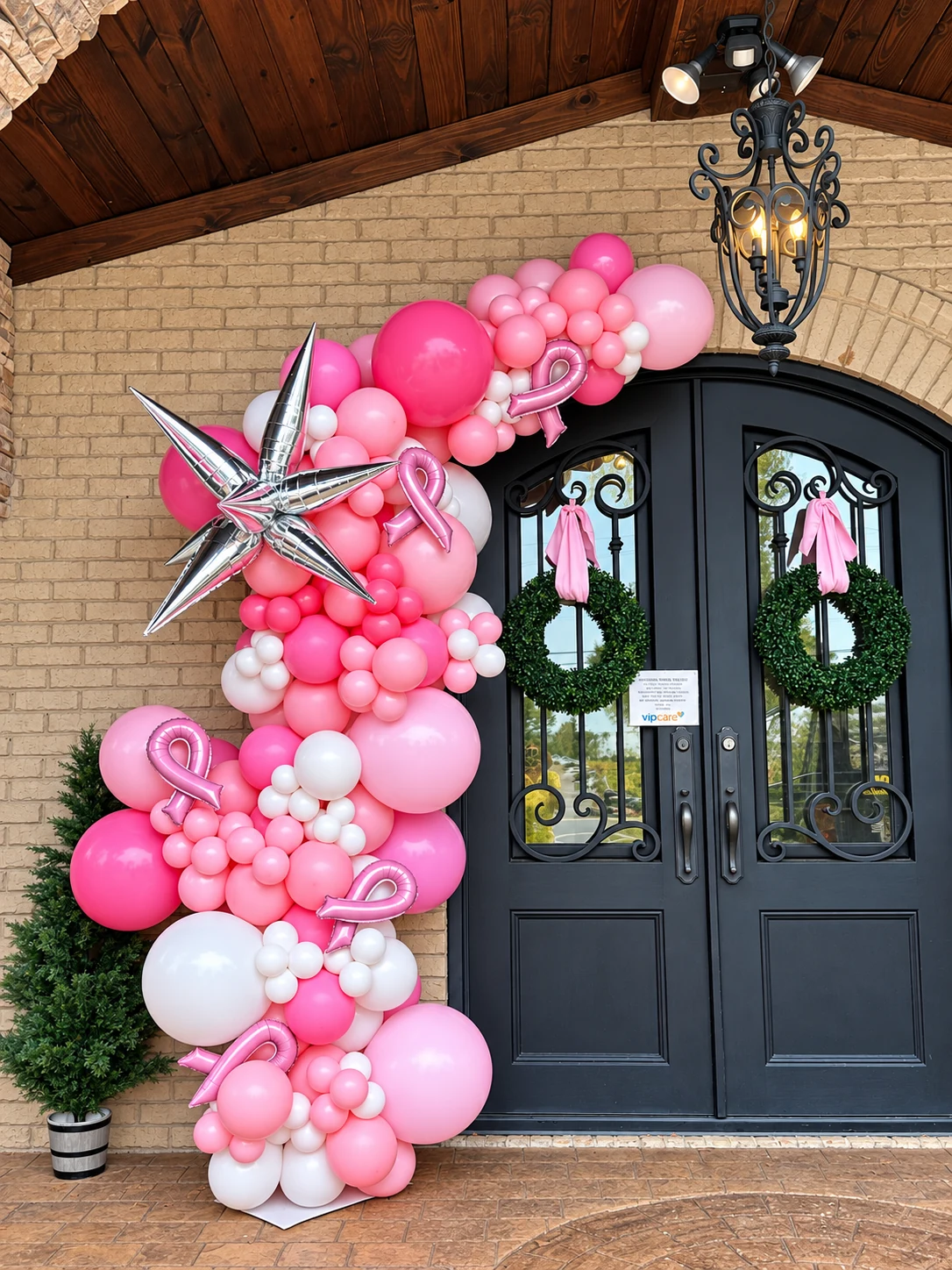 Pink organic balloon garland around a double-door entrance