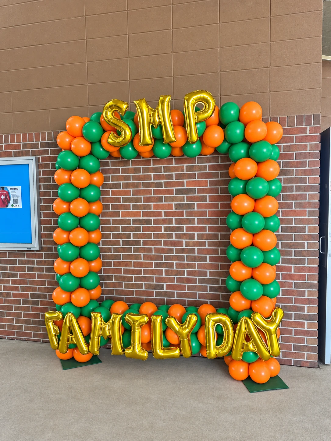 Orange and green Family Day balloon arch