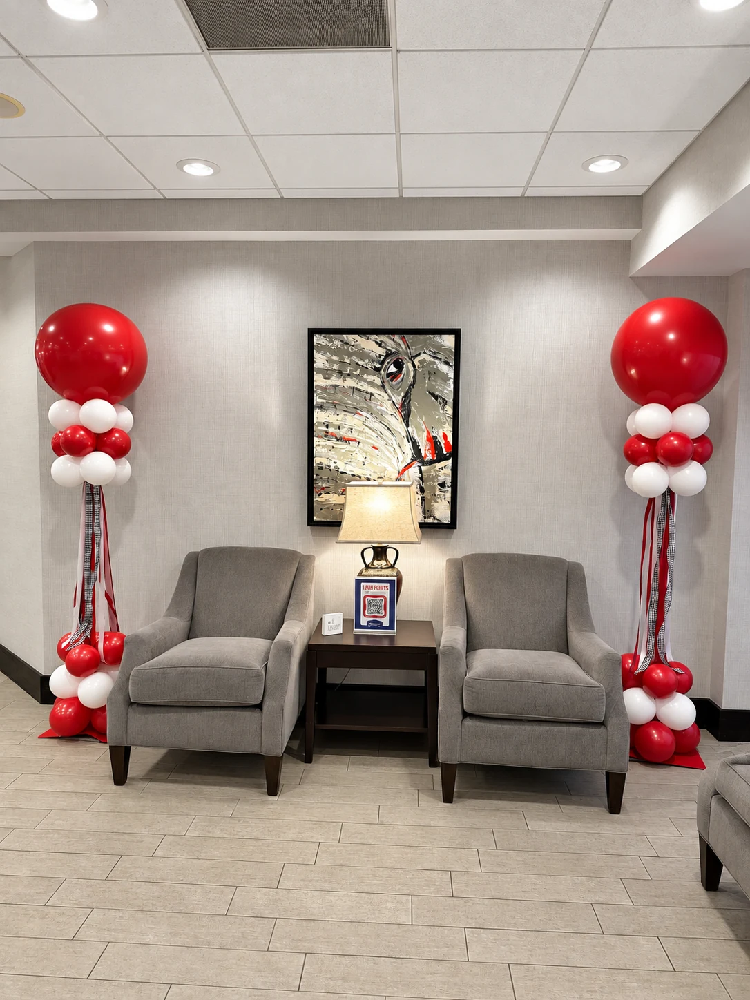 Pair of crimson and white balloon columns in a lobby seating area