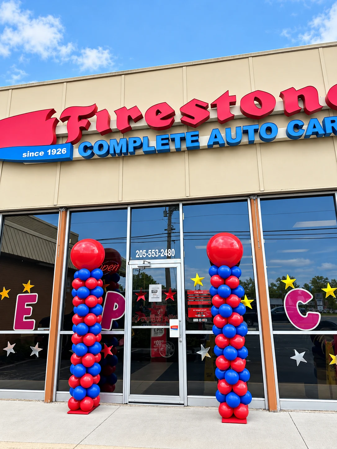 Red and blue balloon columns at a storefront grand opening