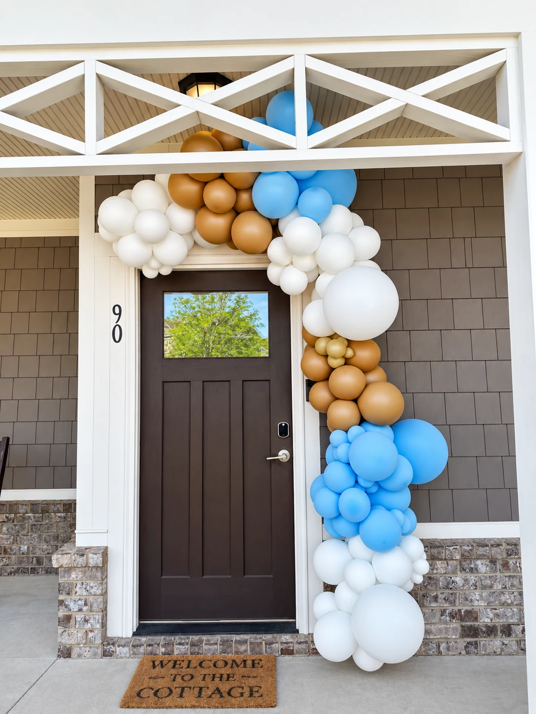White, tan and blue organic balloon garland around a doorway