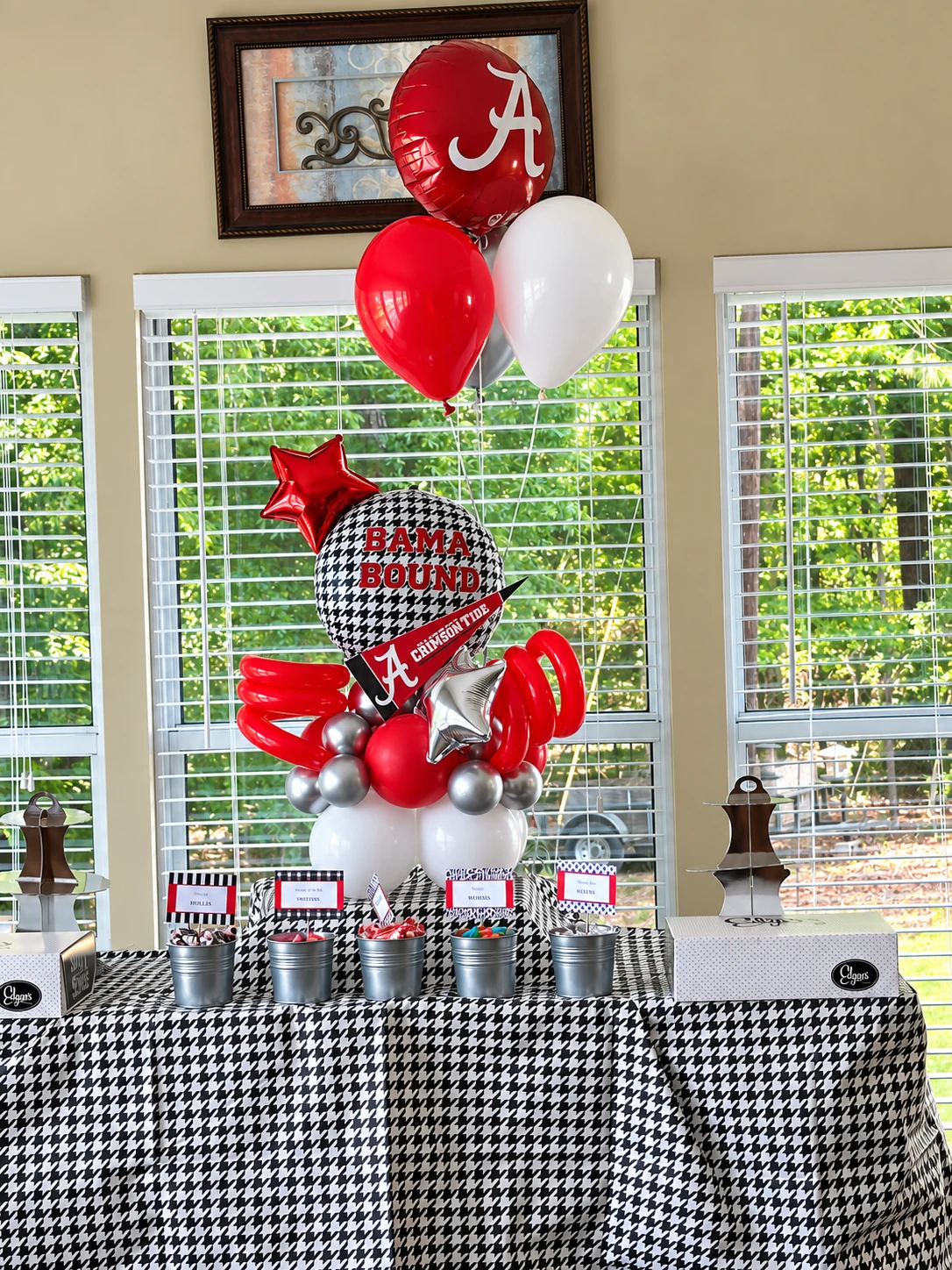 Crimson sports-themed dessert table with balloon bouquet
