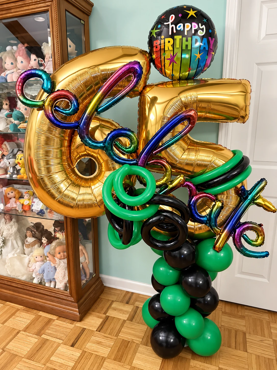 Gold 65th birthday balloon number sculpture with green and black accents