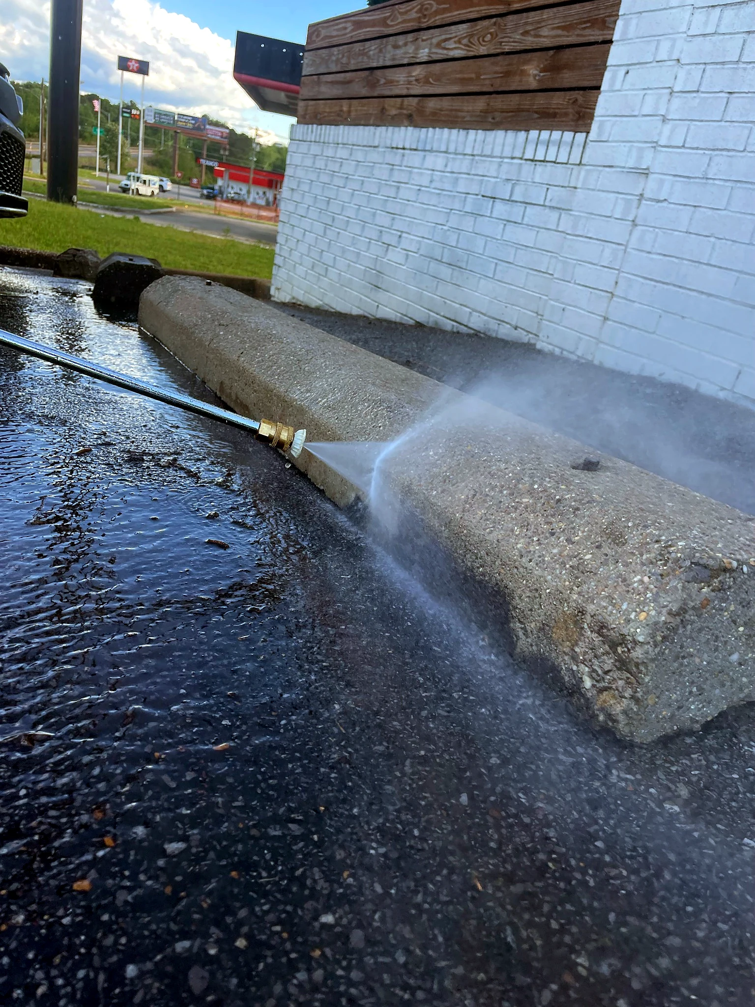 Pressure Point Services pressure washing a concrete parking curb